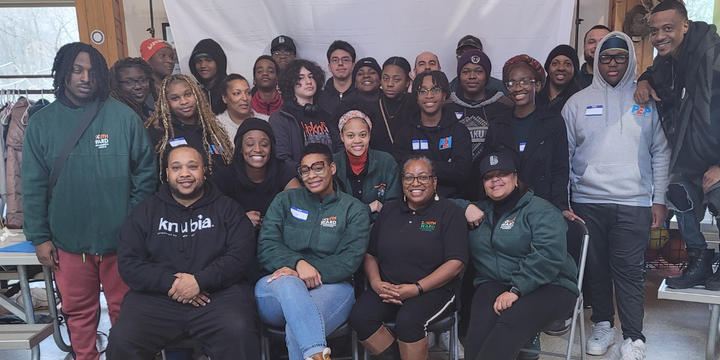 Black and brown people sitting, staff and youth from the South Ward Envir