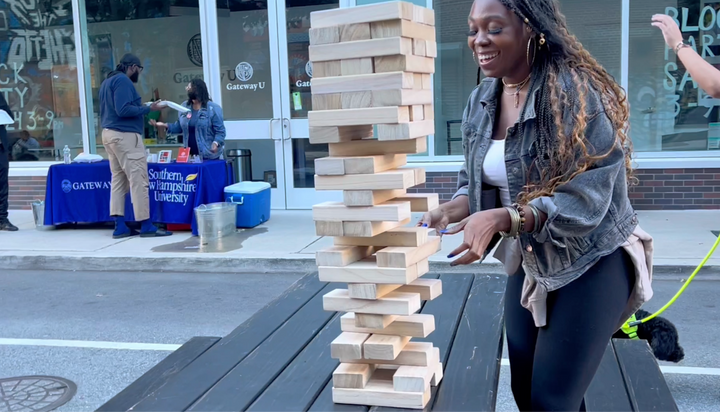 All smiles. Young woman playing Jenga.